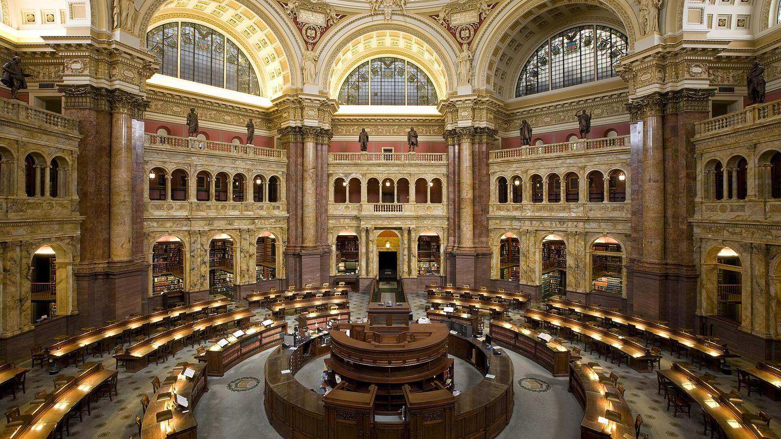 The domed Main Reading Room of the Library of Congress, with rings of wooden desks under tall arched windows